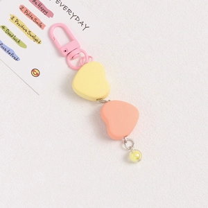 Close-up of heart-shaped keychain with pink metal clasp and matte resin pendants