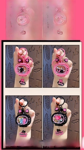 Detail of cute glowing cat TV keychains in pink and black with acrylic charms