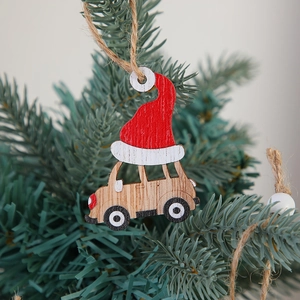 Wooden Christmas car ornament with red Santa hat hanging on a festive green pine tree