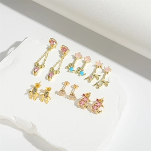 Close-up of gold-plated bear and animal earrings set with colorful zircon stones