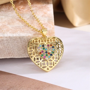 Detailed macro view of a gold heart pendant with colorful zircon stones on a stone surface