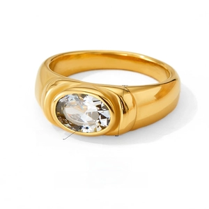 Macro detail of gold stainless steel ring featuring a large oval clear zircon stone