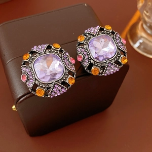 Detailed macro view of vintage square purple crystal earrings with colorful rhinestones