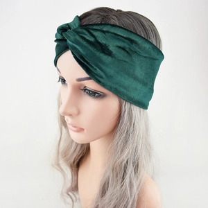 Detailed texture of a dark green velvet twisted headband on a display model