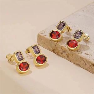 Gros plan de boucles d'oreilles dorées avec pierres violettes et rouges ovales