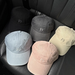 Detail showing five cotton baseball caps with F letter embroidery on a leather car seat