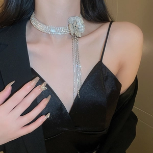 Dettaglio del choker a fiore in argento con strass e nappe lunghe su una modella