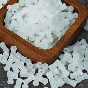 Macro detail of translucent white bamboo-shaped glass beads for DIY jewelry making