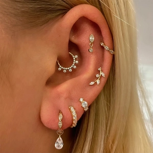 Macro view of gold S925 sterling silver ear cuffs and hoops set with sparkling crystals