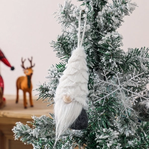 Plush Christmas gnome hanging ornament with white beard on a snowy festive tree branch
