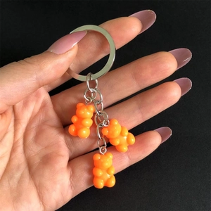 Close-up of three orange translucent resin bear pendants on a metal keychain