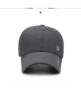 Detail view of quick-dry mesh cap in dark grey with white letter M patch and side printing