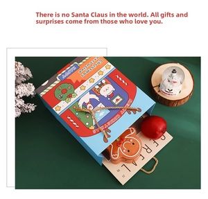 Close-up of blue Christmas gift bag with Santa Claus, reindeer patterns and golden handles