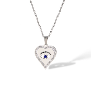 Detailed close-up of heart-shaped evil eye pendant with blue gem and silver chain