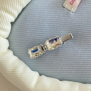 Detail of silver hair clip featuring two rectangular AB crystals with diamond accents