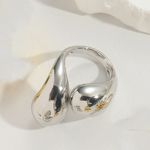 Macro shot of polished silver fluid ring with a glossy water drop design and mirror finish