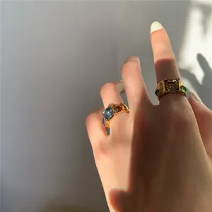 Detail of vintage gold-textured rings with colorful blue and green gemstones