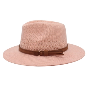 Close-up of pink woven sun hat featuring a fine texture and brown leather strap with buckle