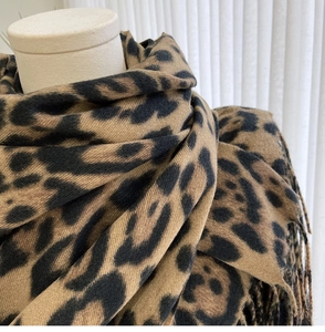 Detailed view of leopard print scarf texture with soft fringe edges and fabric pattern