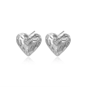 Detailed view of heart studs with hammered texture and sparkling zircon inlay