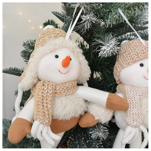 Close-up of plush snowman ornaments with knit hats and scarves on a Christmas tree