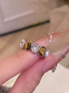 Detail view of tiger eye stone and zircon gemstones on a silver adjustable ring band