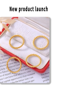 Macro detail of four gold beaded stacking rings displayed on a premium gift box