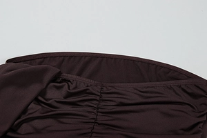 Detailed close-up of dark brown ruched fabric showing fine stitching and matte satin texture
