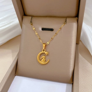Detail view of a gold rabbit on crescent moon pendant inside a velvet jewelry box