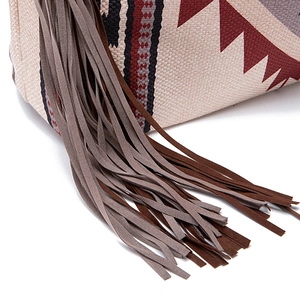 Close-up of bohemian woven tote bag featuring geometric patterns and fringe tassels