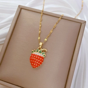 Detailed close-up of a red strawberry pendant necklace on an elegant jewelry box