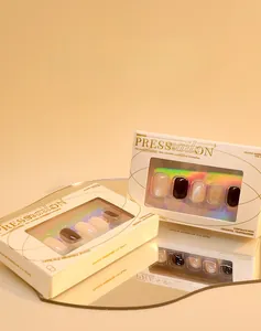 Close-up of cat eye press-on nails in beige and brown boxes with mirror reflection