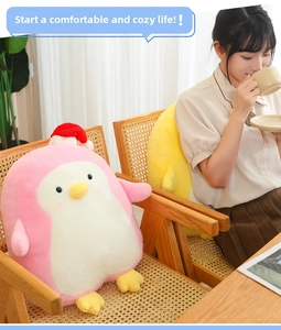 Adorable pink penguin plush toy wearing a Santa hat shown in a cozy home setting
