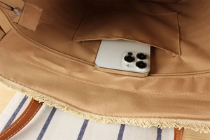 Internal detail of woven tote with brown lining, phone pocket, and zipper closure