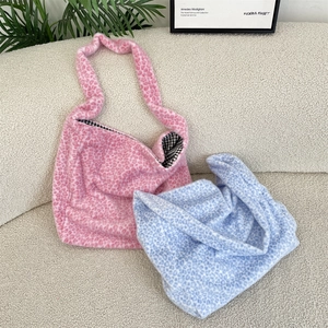 Close-up of leopard print plush tote bags in pink and blue with checkered lining fabric