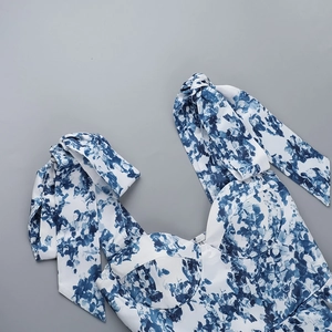 Détail de robe florale bleue et blanche montrant des bretelles et un corsage structuré
