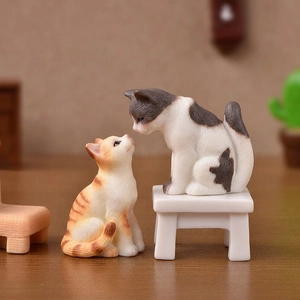 Realistic resin cat figurines with kitten duo interacting on a miniature wood stool