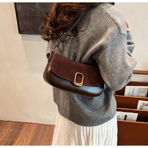Detail of dark brown vintage shoulder bag showing suede splicing and golden buckle