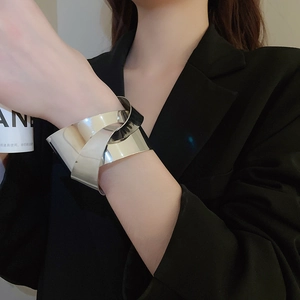 Detail showing the polished silver layered knot design of this modern wide metal cuff bracelet