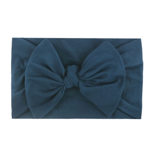 Soft nylon baby headband featuring an oversized dark navy blue bow on white background