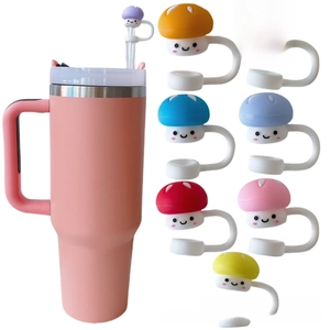 Pink insulated tumbler with 8 colorful mushroom-shaped silicone straw toppers and smile faces