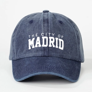 Detail of washed navy baseball cap featuring white vintage Madrid city embroidery texture