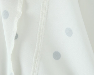Vue macro de la texture du tissu à pois bleu clair et détails de double couture