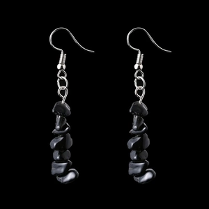 Detail shot of irregular black natural stone beads on long silver dangle earrings