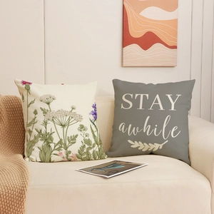 Floral print and Stay Awhile text pillow covers on a cozy sofa for modern living decor