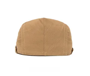 Detail view of the back of a light brown cotton newsboy cap showing stitching and strap