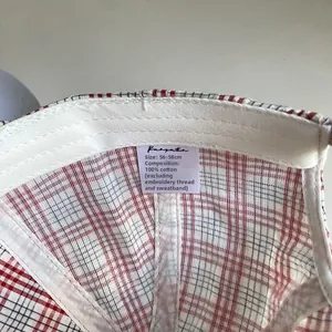 Détail de la casquette en coton à carreaux avec doublure intérieure et étiquette de lavage
