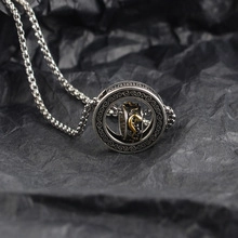 Macro shot of retro silver necklace with rotating devil eye pendant and gold details