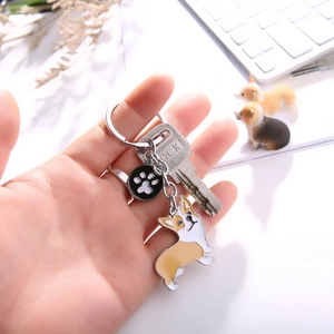 Detail of Corgi dog enamel keychain with metal ring and white paw print charm
