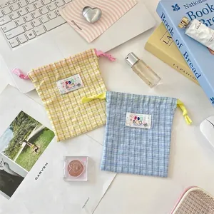 Gingham checkered drawstring storage bags in yellow and blue for cosmetics and travel